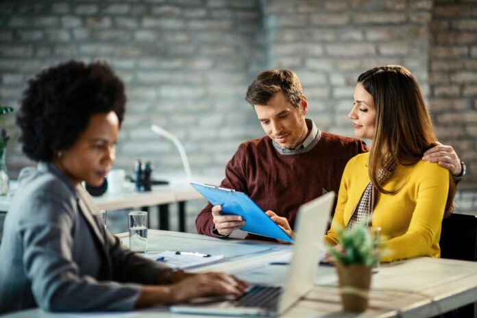 embraced-couple-reading-loan-agreement-while-having-meeting-with-their-bank-manager-office_637285-914